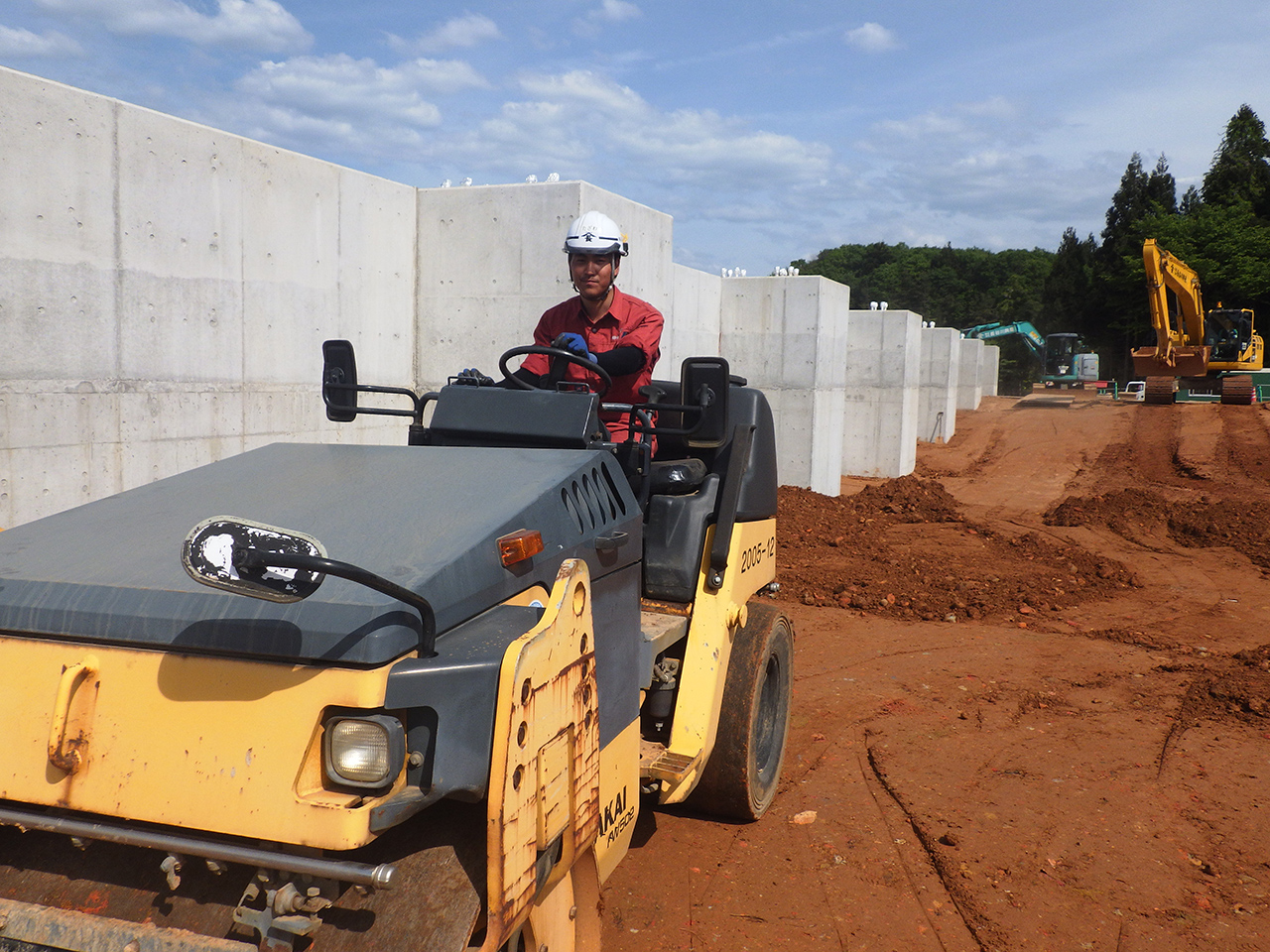 コンクリート構造物を土砂で埋戻し転圧ローラーで締固め作業を行う構造力学が得意なT君
